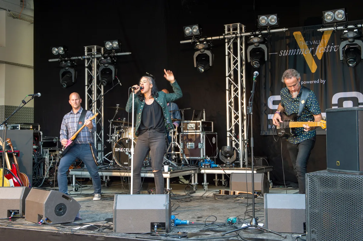 Man sieht eine Band auf der Bühne.